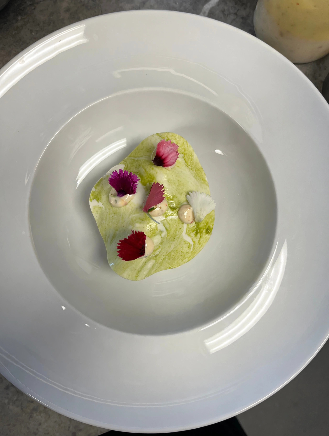 Dessert délicat aux fleurs comestibles dans une assiette blanche